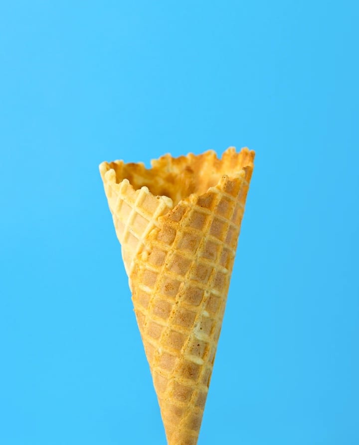 An empty ice cream cone on a blue background