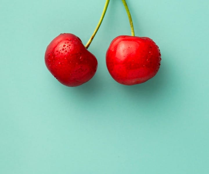 Two really fresh cherries with water dripping